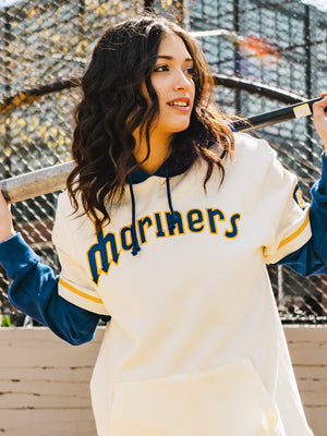 Woman wearing a Mariners cream Shortstop hoodie.